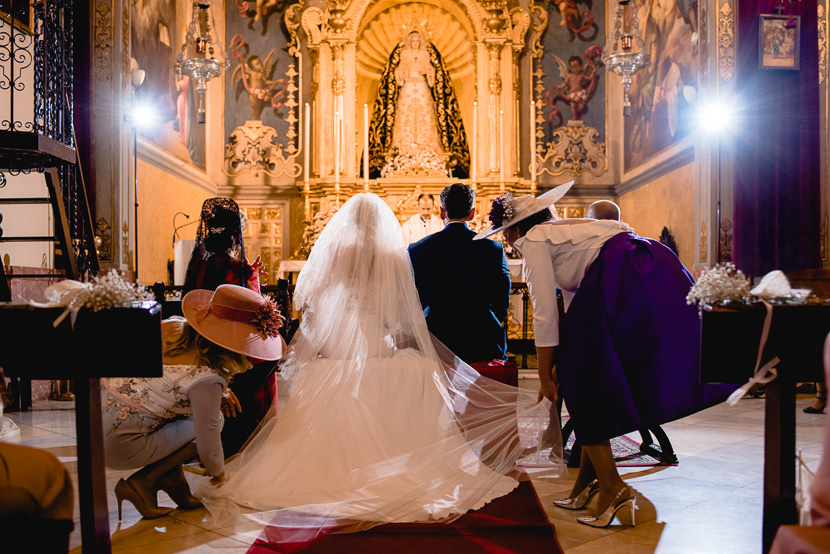 Pareja de novios casandose frente a la Virgen de Nuestra Señora de los Angeles en su Boda en la Hermandad de los Negritos, fotografía por Moisés García para Bodas con Arte, fotógrafo de bodas en Sevilla Este.